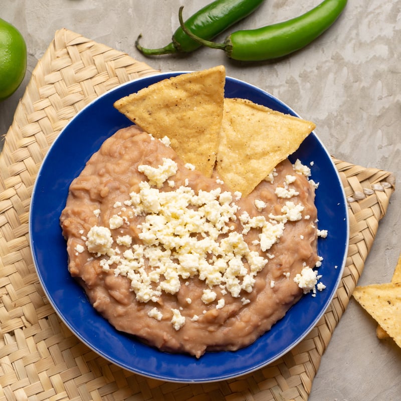 Mexican refried beans with cheese and totopos