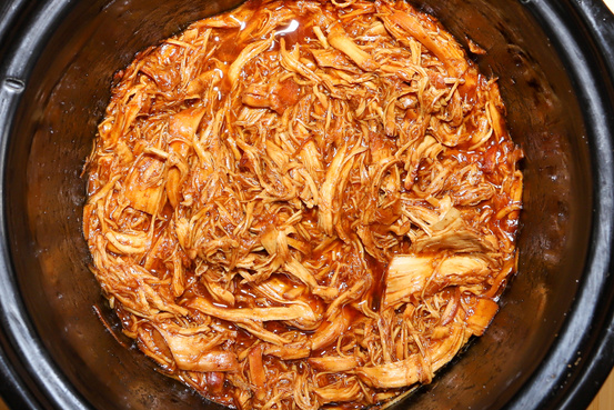 Shredded  bbq chicken cooking in a crockpot